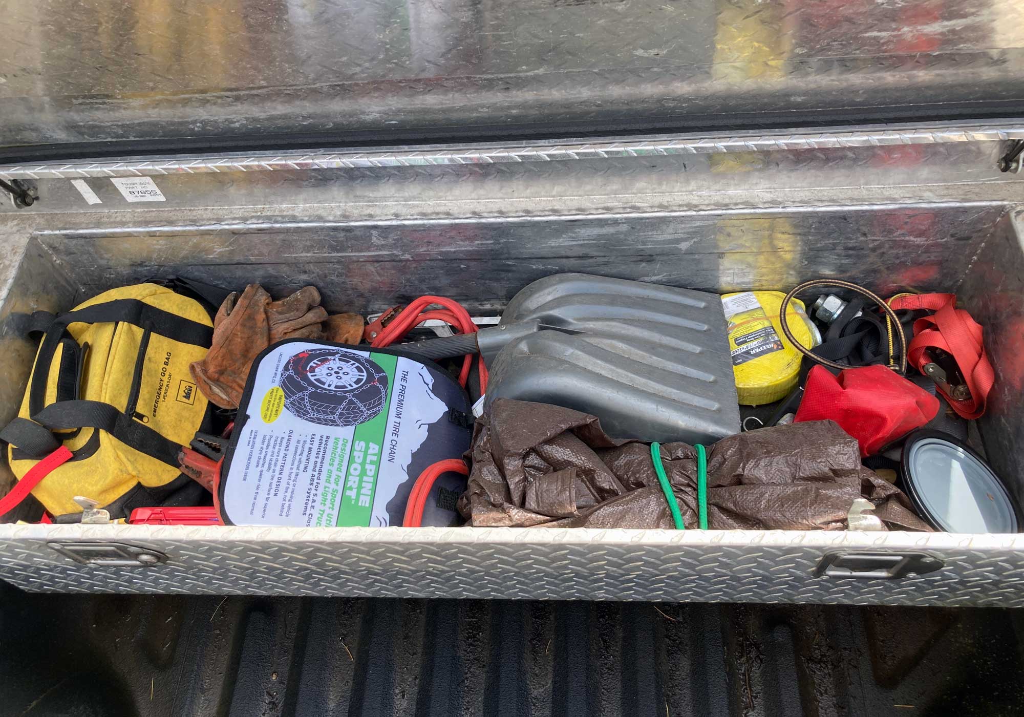 Truck toolbox, a mess of jumper cables, shovels, straps, and tools