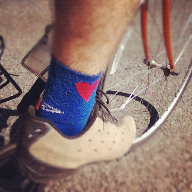 Blue sock with heart design in a bike shoe pedaling a bike