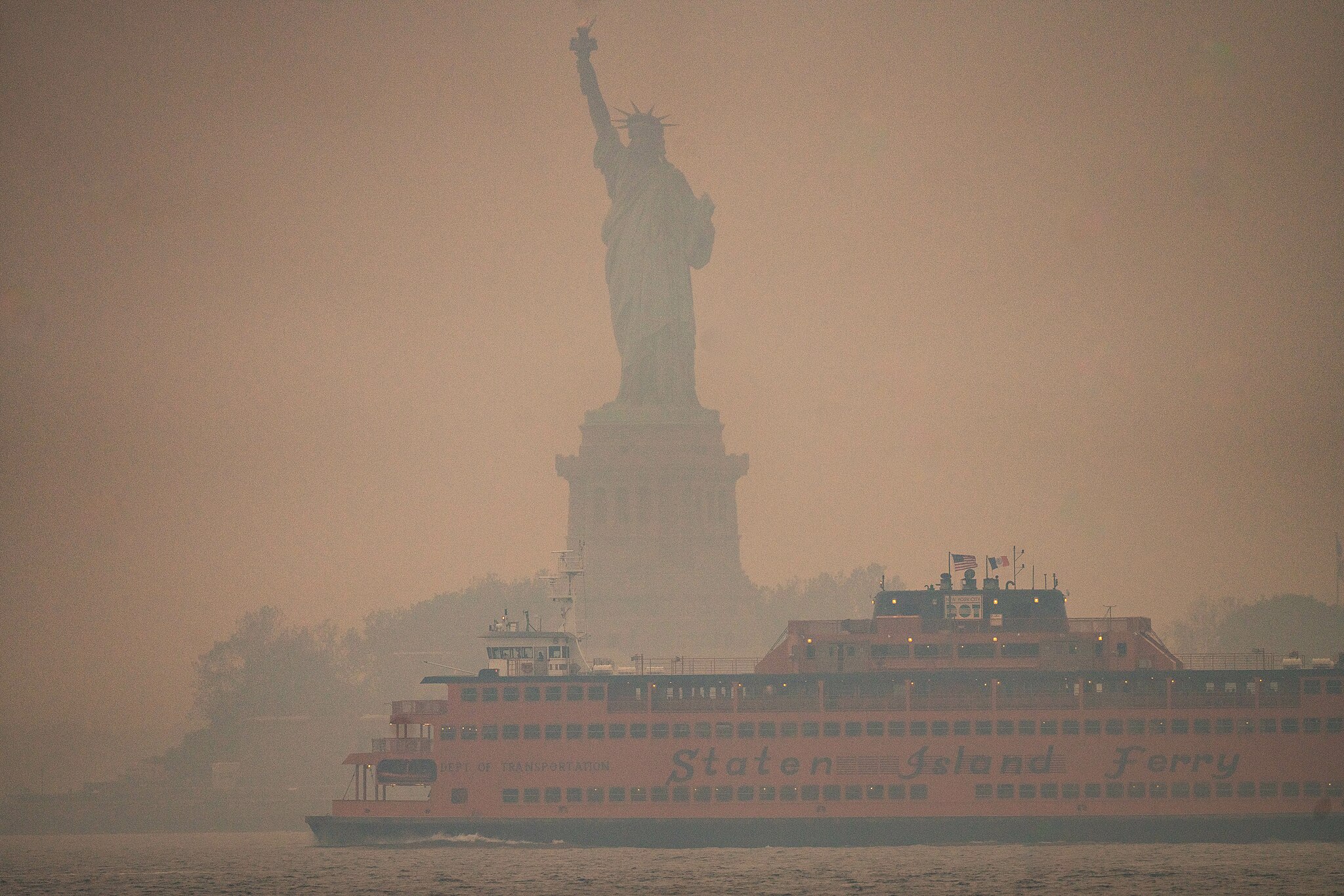 Dense, putrid smoke obscures the Statue of Liberty, with the massive Staten Island Ferry in the foreground