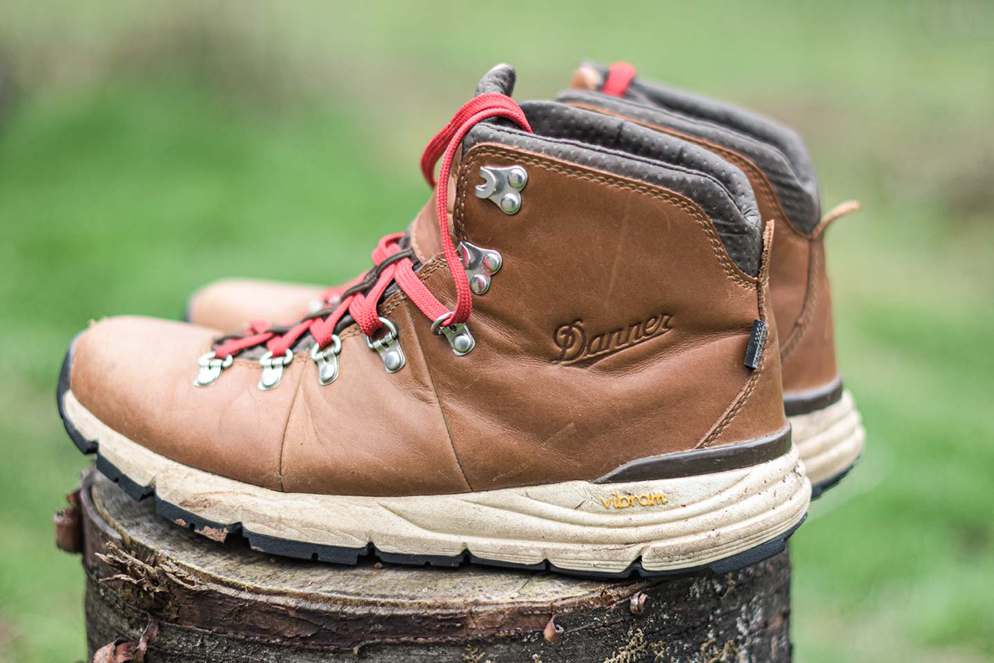 Brown boots with red laces with Danner embossed on the side, and a white sole