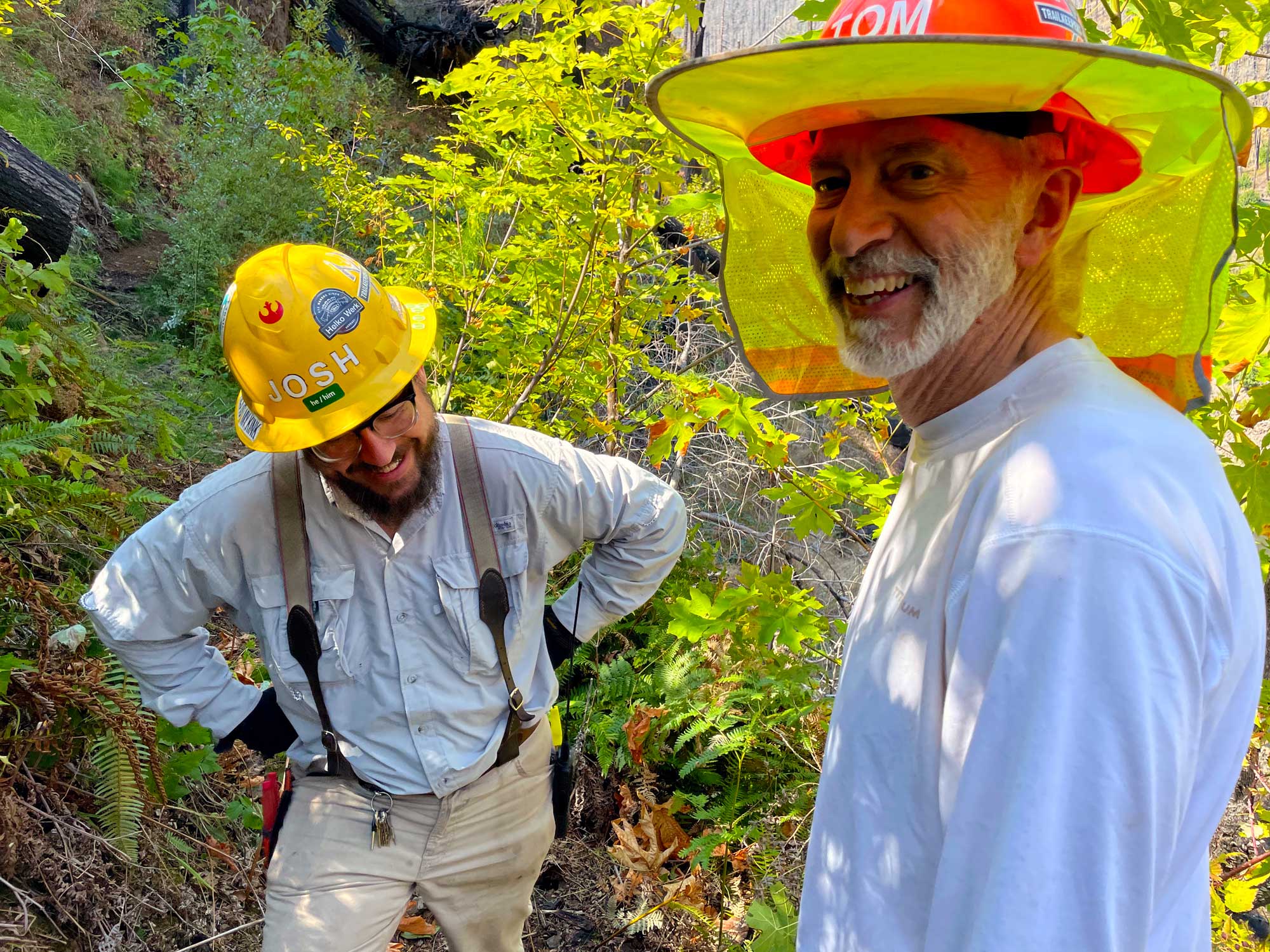 Two men in hardhats smiling and laughing