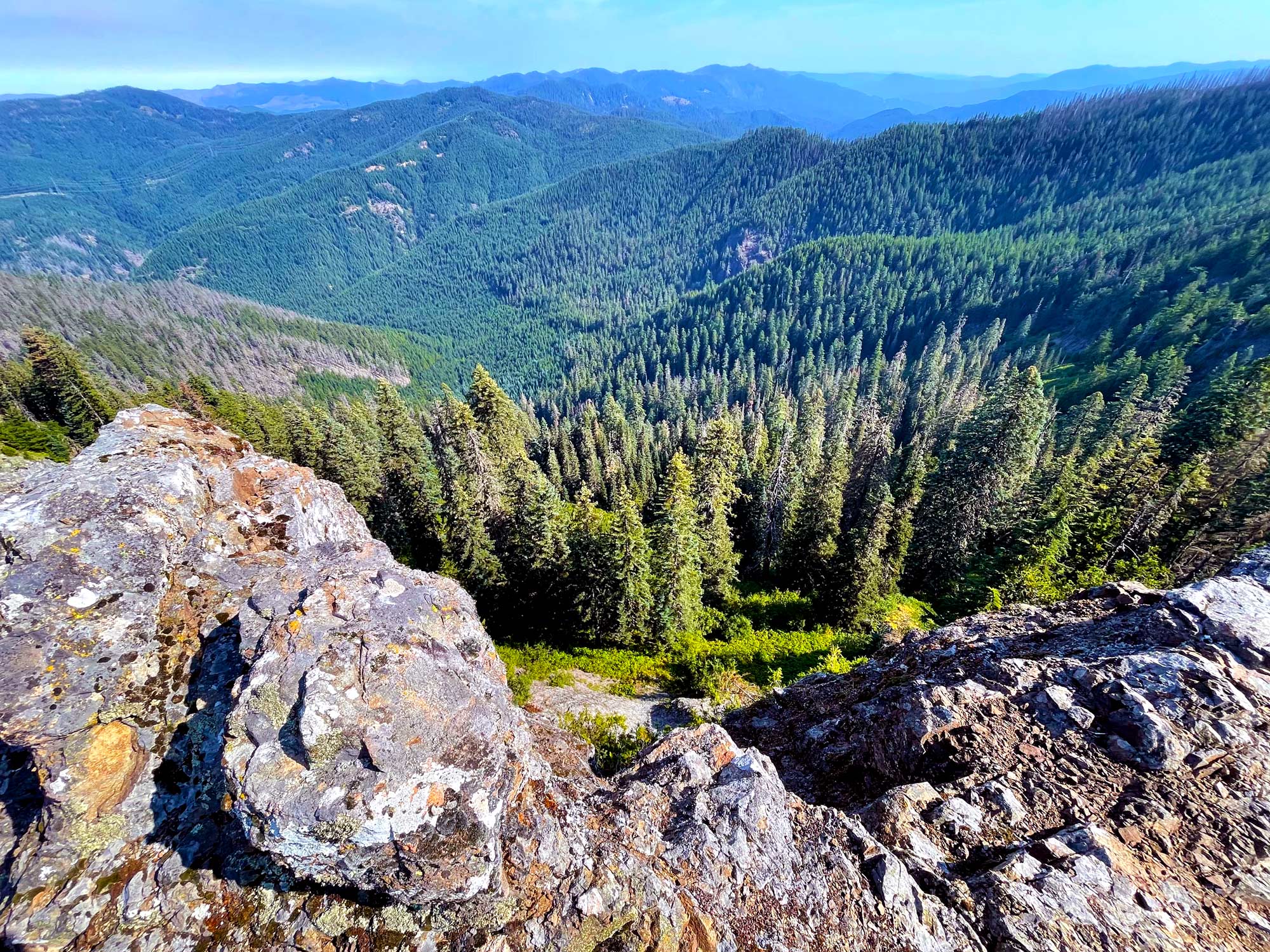 Looking from a rock ledge with tree covered hills and valleys