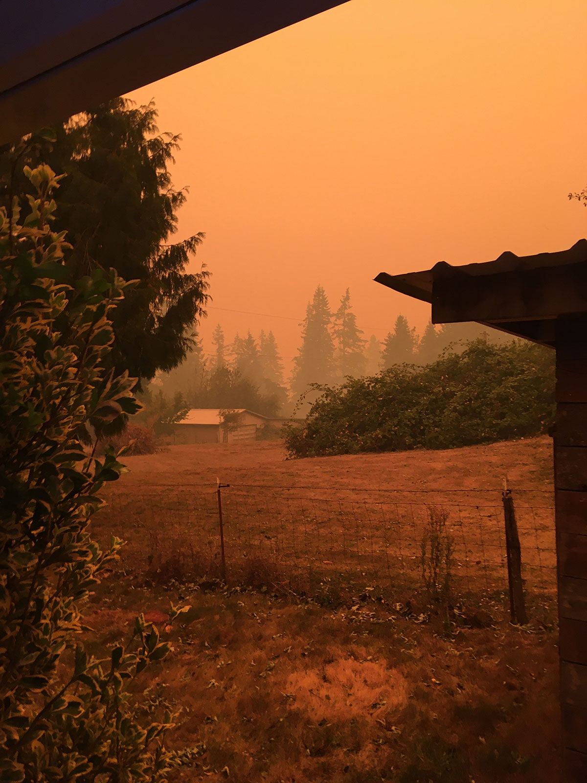 orange sky with smoke in the distance of an outbuilding