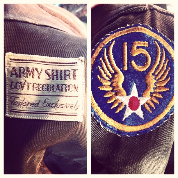 Two photos in one, with the left showing a tag that reads Army shirt gov't issued, and tailored exclusively, and the right side showing a patch with the number 15 and wings extending from a white star with a red circle in the middle