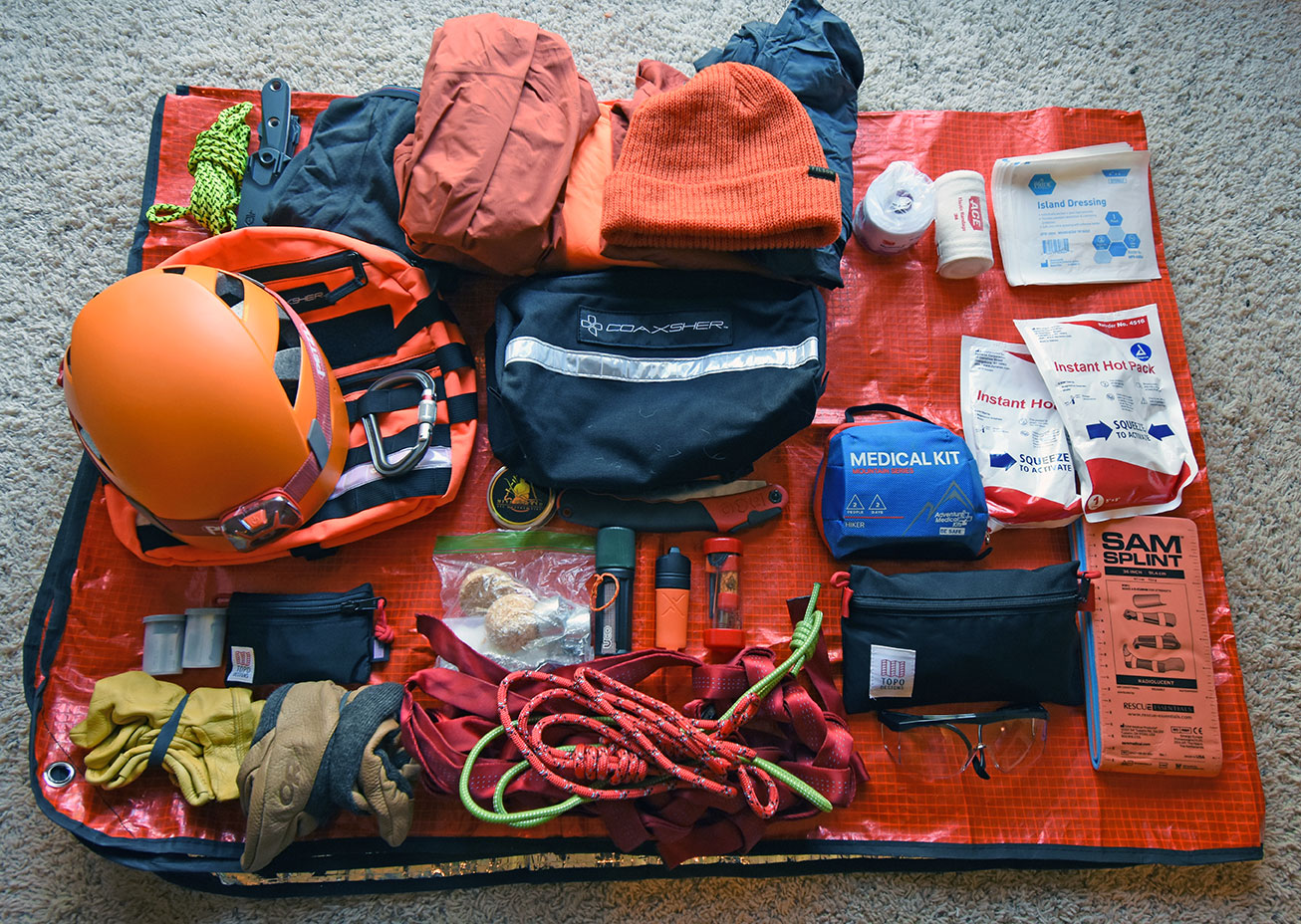 Coaxsher pack modules, ropes, webbing, medical supplies, fire starters, matches, gloves, spare batteries, saw, knife, and helmet